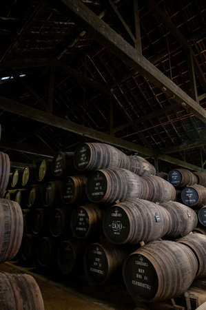 Old porto lodge with rows of oak wooden casks for slow aging of fortified ruby or tawny porto wine in Vila Nova de Gaia, north of Portugalの写真素材