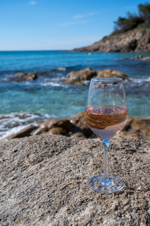 Summer time in Provence, glass of cold rose wine on sandy beach and blue sea water near Saint-Tropez in sunny day, Var department, Franceの写真素材