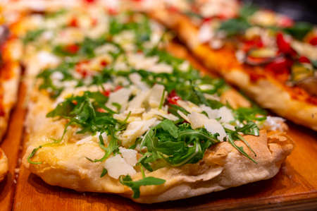 Fresh baked focaccia or pala romana pizza with vegetables and cheese in bakery in Parma, Emilia Romania, Italyの写真素材