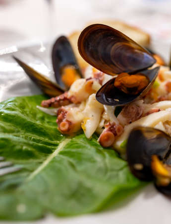 Tasty salad with boiled octopus, potatoes, olive oil and mussels served in Italian restaurantの写真素材