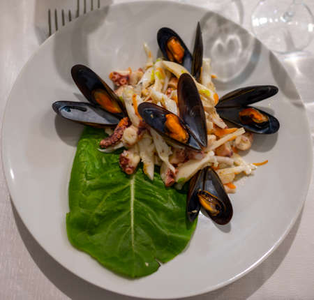 Tasty salad with boiled octopus, potatoes, olive oil and mussels served in Italian restaurantの写真素材