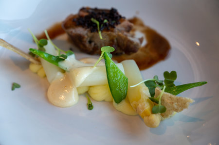 Roasted beef tenderloin served with white asparagus and green peas in gastronomic restaurant