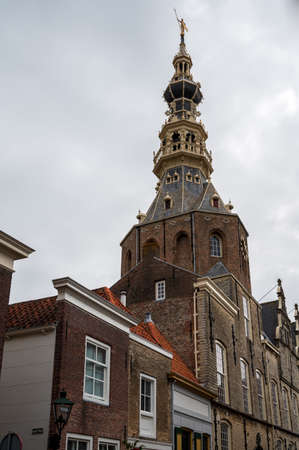 Walking in old Dutch town Zierikzee with old church tower, small houses and streets, Zeeland,...