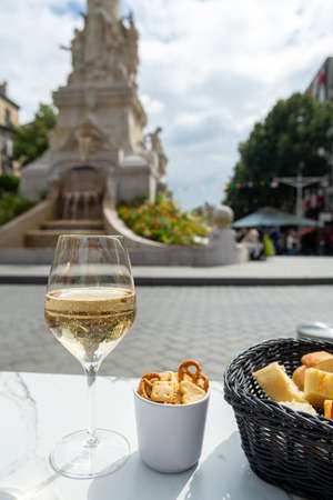 Drinking of brut champagne sparkling wine in street cafe with view on old central part of city...