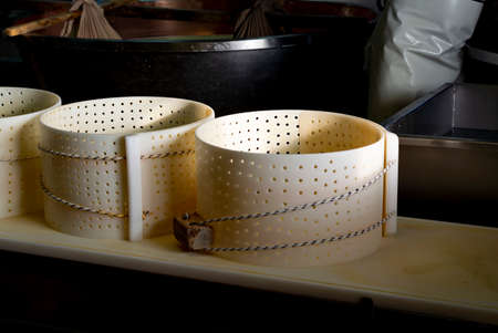 Traditional process of making from cow milk wheels of parmigiano-reggiano parmesan cheese on small cheese farm in Parma, Reggio-Emilia, Italyの写真素材