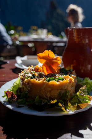 Dinner at guachinche, typical Canary Island establishment on Tenerife, where locally produced white or red wine served accompanied by homemade traditional food in sunny day, sweet potato salad with green lettuceの写真素材