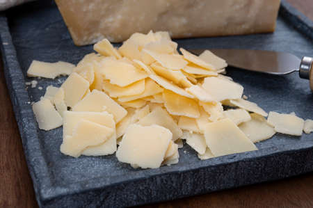 Flakes of parmesan cheese, italian hard parmigiano-reggiano cheese from Reggio Emilia region, close upの写真素材