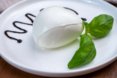 Tasing of fresh italian cheese mozzarella di buffalo with Balsamic vinegar from Modena close upの写真素材