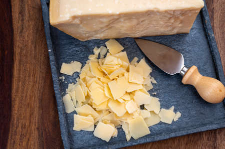 Flakes of parmesan cheese, italian hard parmigiano-reggiano cheese from Reggio Emilia region, close...