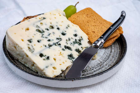 Tastig of French king of cheeses, sheep milk blue cheese roquefort from Southern France, close up