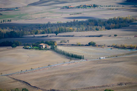 Aerial view on hills of Val d'Orcia near Castiglione d'Orcia, Tuscany, Italy. Tuscan landscape with cypress trees, vineyards, forests and plowed fields in sunny autumn.の写真素材