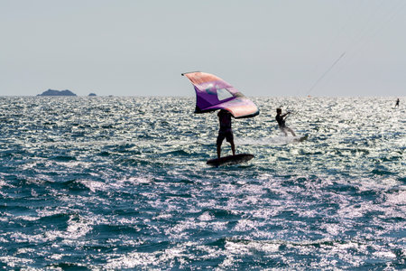 2021. Extreme water sports - wing foil, kite surfing, wind surfindg, windy day on Almanarre beach near Toulon, South of Franceのeditorial素材