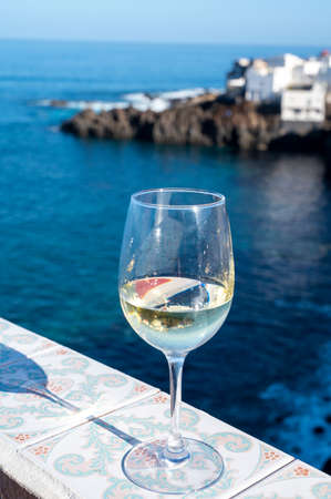 Drinking of cold verdejo white wine with view on blue Atlantic ocean on Tenerife, Canary islands, Spainの写真素材