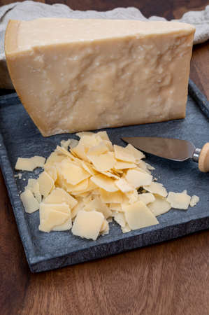 Flakes of parmesan cheese, italian hard parmigiano-reggiano cheese from Reggio Emilia region, close up