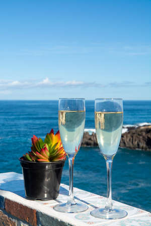 New year celebration with two glasses of champagne or Spanish cava sparkling wine and view on blue...