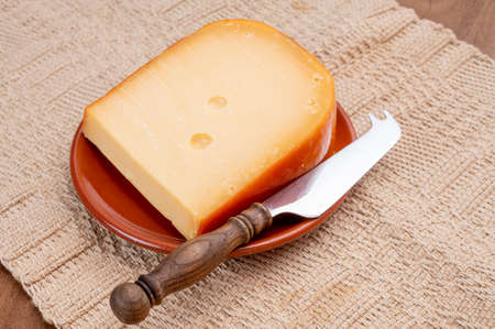 Dutch hard cow milk old yellow cheese from Goudaの写真素材