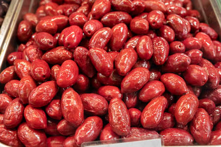 Red olives close up on market, healthy vegetarian food backgroundの写真素材