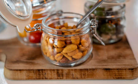 Glass jars with healthy party snacks served in bar, tasty appetisers cherry tomatoes, oliver asnd...