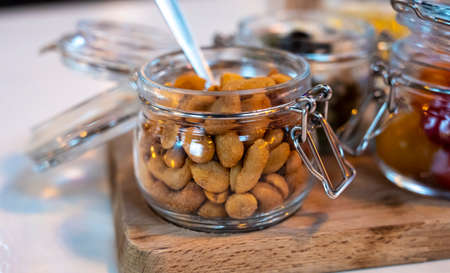 Glass jars with healthy party snacks served in bar, tasty appetisers cherry tomatoes, oliver asnd peanut nutsの写真素材