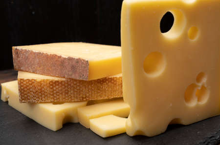 Swiss cheese collection, emmentaler with holes, gruyere, appenzeller fondue cheeses close up