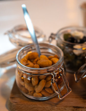 Glass jars with healthy party snacks served in bar, tasty appetisers cherry tomatoes, oliver asnd...
