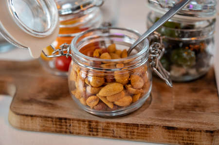 Glass jars with healthy party snacks served in bar, tasty appetisers cherry tomatoes, oliver asnd peanut nutsの写真素材