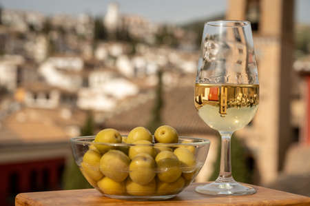 Tasting of Spanish sweet and dry fortified Vino de Jerez sherry wine and green olives on roofs and houses of old andalusian town, South of Spainの写真素材