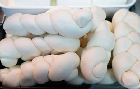 White soft braid cow cheese on market display