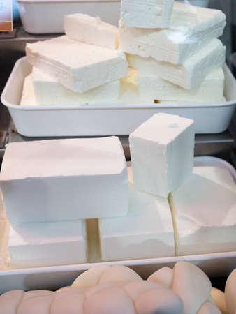 White soft salted feta and bulgarian cheeses on market displayの写真素材
