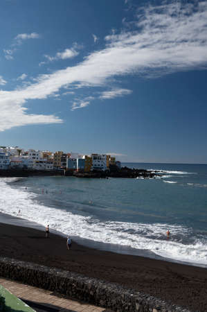 View on colorful houses and black lava rocks in small fisherman village Punta Brava near Puerto de...