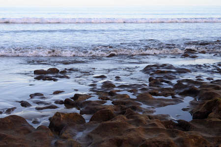Relaxing evening time at sunset on sandy beach in El Medano, south of Tenerife island, Canary, Spain