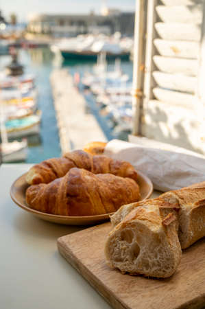 Summer morning in Provence, traditional breakfast with fresh baked croissants and baguette bread and...