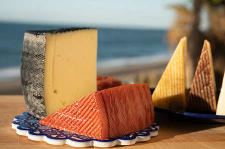 Assortment of Spanish hard cheeses, curado, manchego, goat cheese served outdoor with membrillo jam...