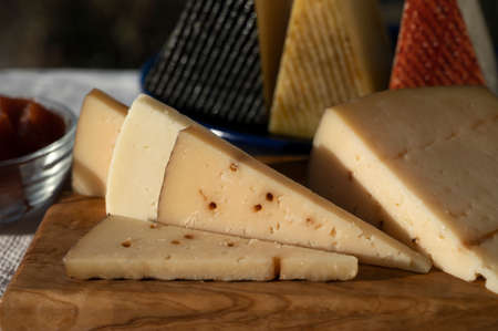 Assortment of Spanish hard cheeses, curado, manchego, goat cheese served outdoor with membrillo jam...