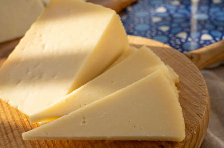Spanish hard manchego, cow, sheep and goat cheese served outdoor in morning sunlights close up
