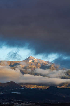 Cloudy panoramic view on Tenerife with snow on peak of Mount Teide, volcatic landscape, Canary islands, Spainの写真素材