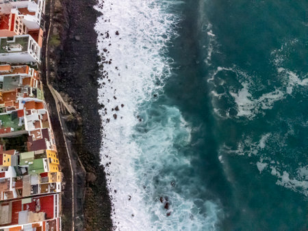 Aerial top view on colorful houses and black lava rocks in small fisherman village Punta Brava near Puerto de la Cruz, Tenerife, Canary islands at sunriseの写真素材