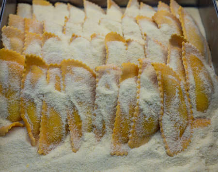 Italian food, handmade mezzaluna pasta ravioli stuffed with four cheeses, uncooked
