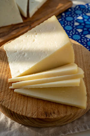 Spanish hard manchego, cow, sheep and goat cheese served outdoor in morning sunlights close upの写真素材