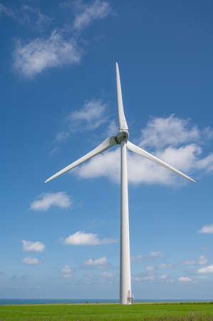 View on modern wind mills, green grain fields and blue Atlantic ocean in agricultural region Pays de...