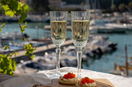Pairing of small blinis with sour cream and salted salmon red caviar and French champagne brut...