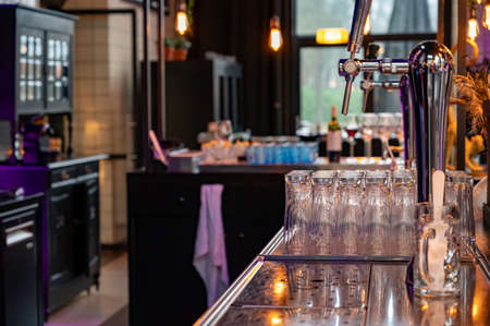 Interior of classic beer and whiskey bar with beer taps and empty glasses in cafe,の写真素材