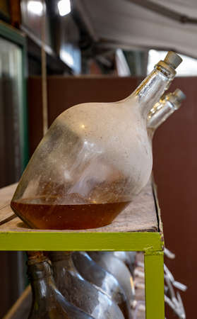 Big bottles with white Austrian wine vinegar made from local grapes on market in Vienna, Austria,...
