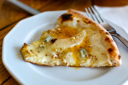 Eating of fresh baked pizza dish in italian pizzeria restaurant, close upの写真素材