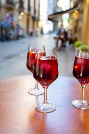 Glasses of cold sangria wine served outdoor in bar with view on old street in San Sebastian, Basque Country, Spain in summerの写真素材