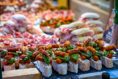 Assortment of typical snacks of Basque Country and Navarre, pinchos or pinxtos, small piece of bread with different toppings, served in bar, Bilbao, Spain, close upの写真素材