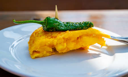 Typical snack in bars of Basque Country, pinchos or pinxtos, small slices of bread withn different toppings and fastened with skewers, lunch in San Sebastian, Spain. Potato tortilla with green pepper.の写真素材