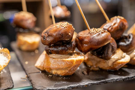 Typical snack in bars of Basque Country and Navarre, pinchos or pinxtos, small slices of bread upon which ingredient or mixture of ingredients is placed and fastened with skewers, San Sebastian, Spain, close upの写真素材