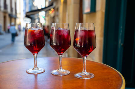 Glasses of cold sangria wine served outdoor in bar with view on old street in San Sebastian, Basque Country, Spain in summerの写真素材