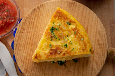 Spanish vegetarian food, portion of homemade tasty potato omlette tortilla de patatas with onion served outdoor in morning sunlightsの写真素材